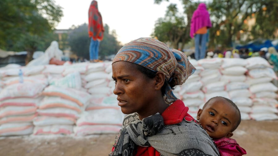 A woman carries an infant in the town of Shire,Ethiopia, March 15, 2021. © Baz Ratner, Reuters